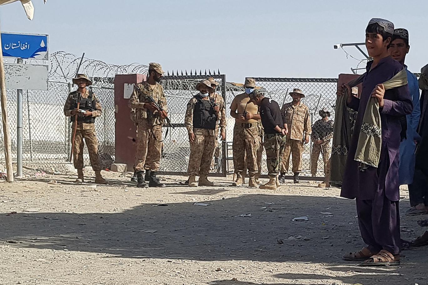 Pakistani paramilitary troops standing guard near the closed border fence at the Chaman crossing point