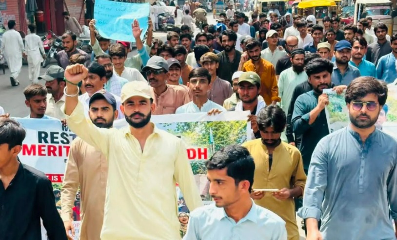 Pakistani youth and candidates marching in a protest rally carrying banners for merit restoration in Sindh.