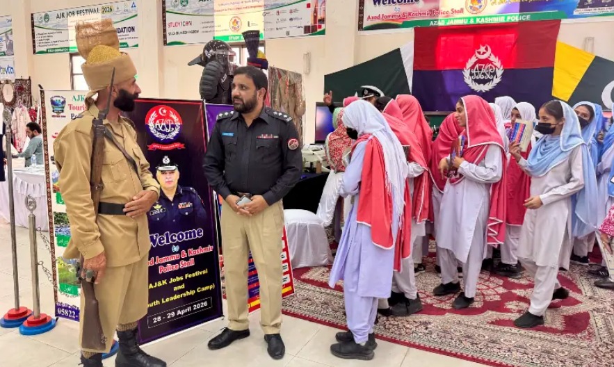 Female students in school uniforms visiting the Azad Jammu and Kashmir Police stall at the AJK Job Festival 2026 in Muzaffarabad.