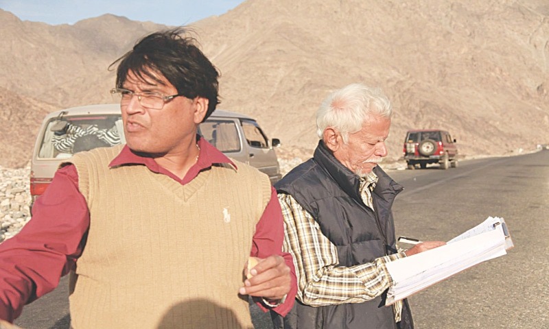 Veteran film director and writer Iqbal Rizvi reviewing a script during an outdoor film shoot in Pakistan.